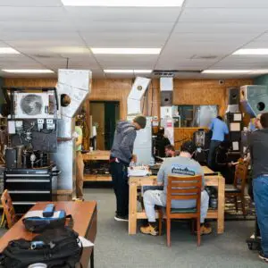 A group of people standing around a room.