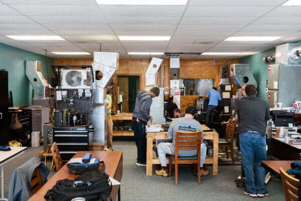 A group of people standing around a room.